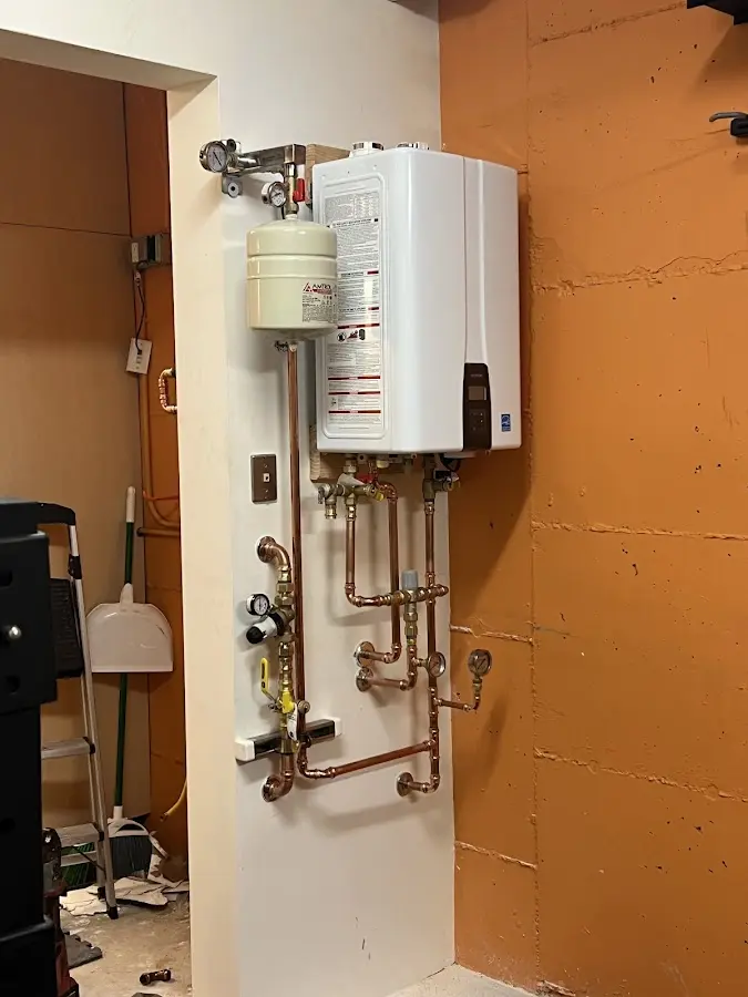 Plumbing technician inspecting water heater connections in Castle Rock